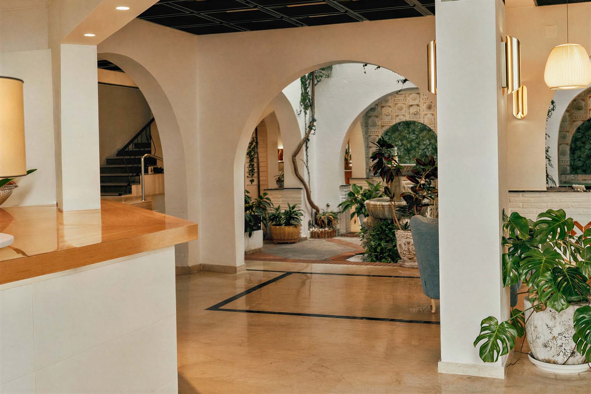 BENESTE: Corporativa, interiores acogedores con plantas y arcos.