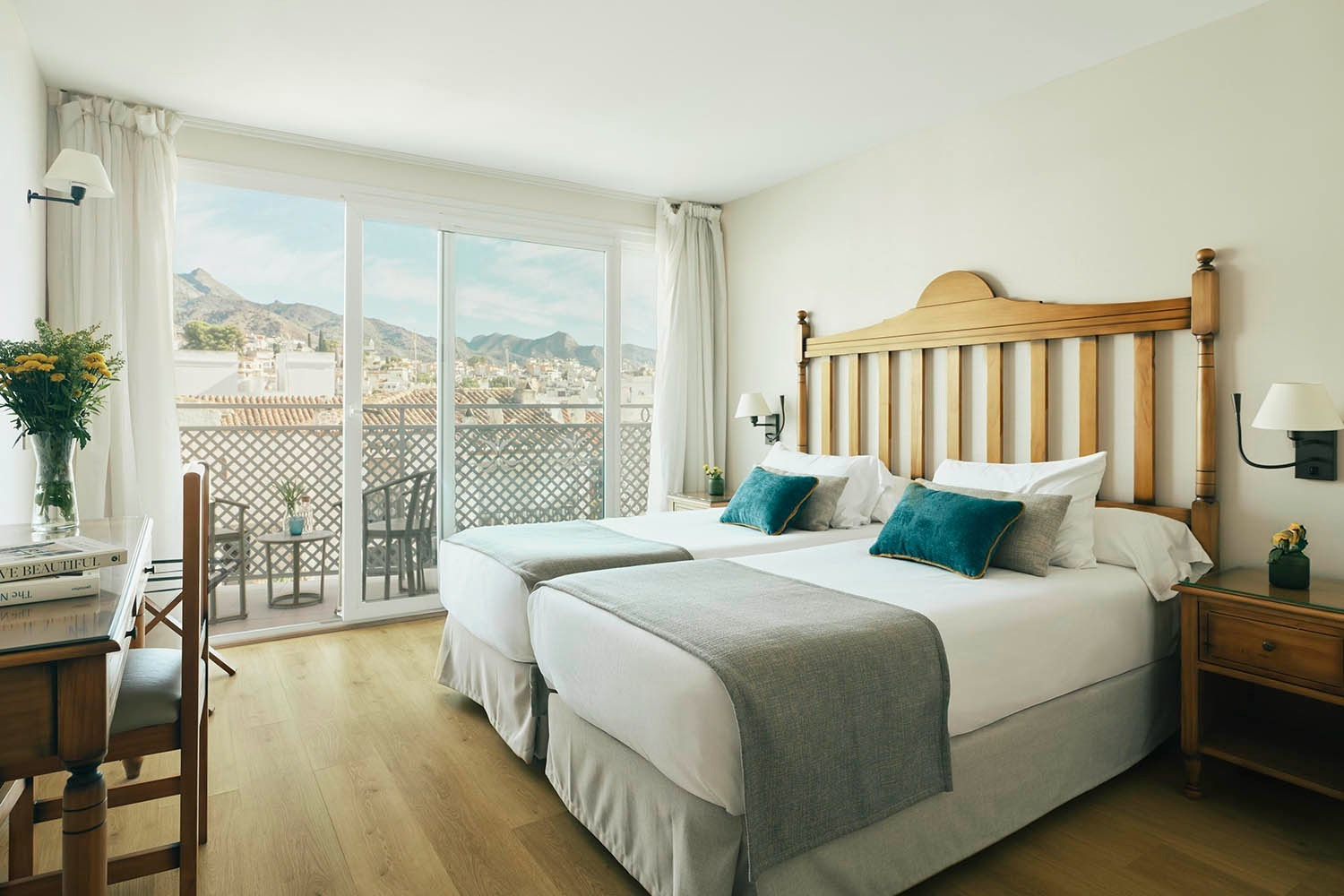 Twin beds in bright hotel room with balcony view | Villa Flamenca