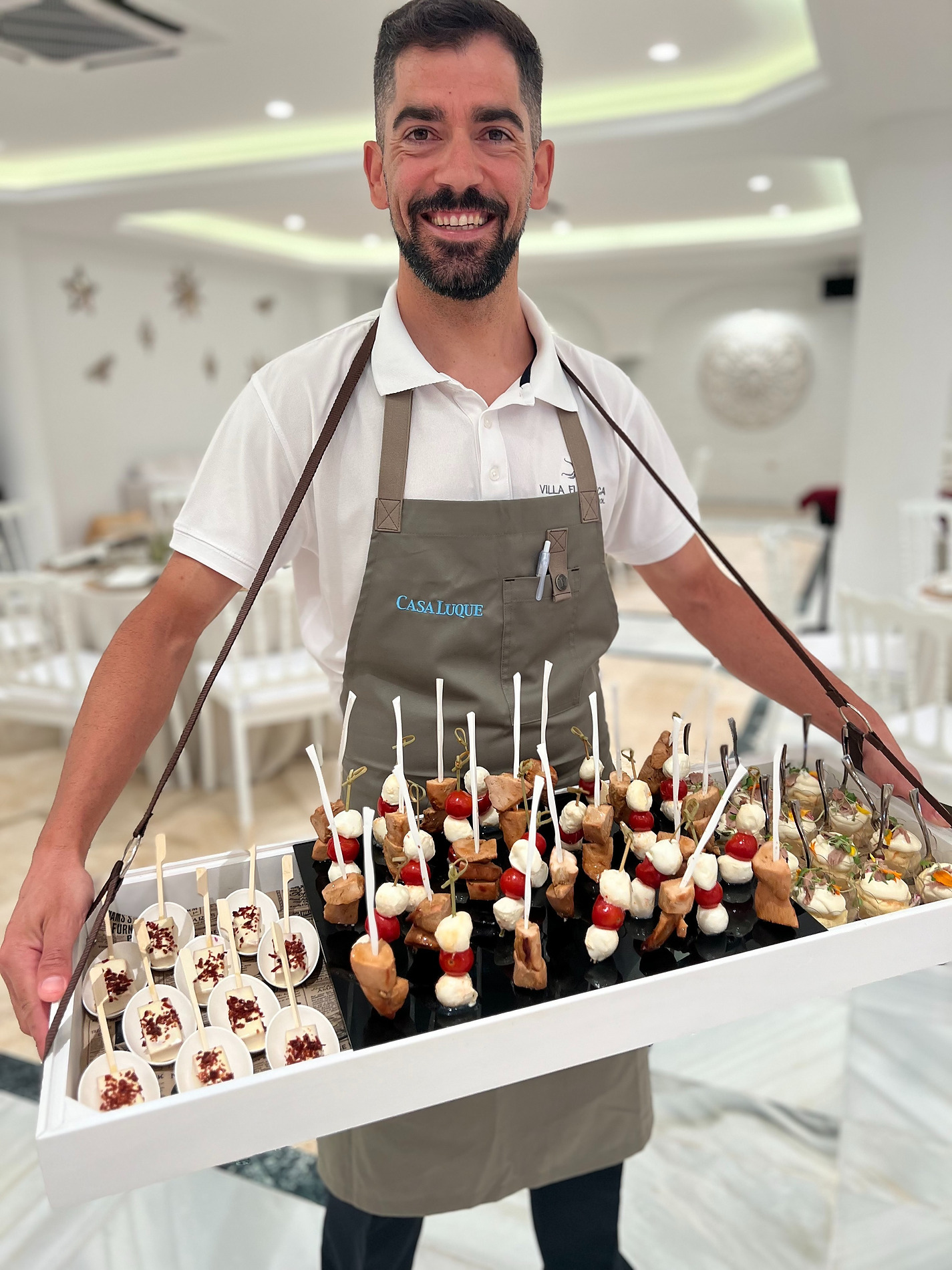 Chef sonriente ofreciendo canapés gourmet para eventos. Eventos | Villa Flamenca | Beneste Hoteles | Web oficial