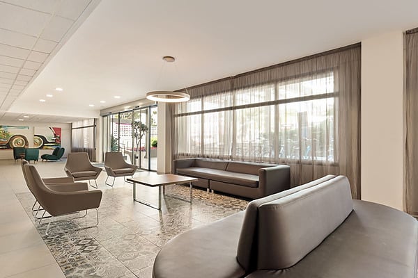Gepolsterte lila Sessel und runde Tische in der Lobby Best Oasis Park, Salou | Offizielle Website | Bester Preis