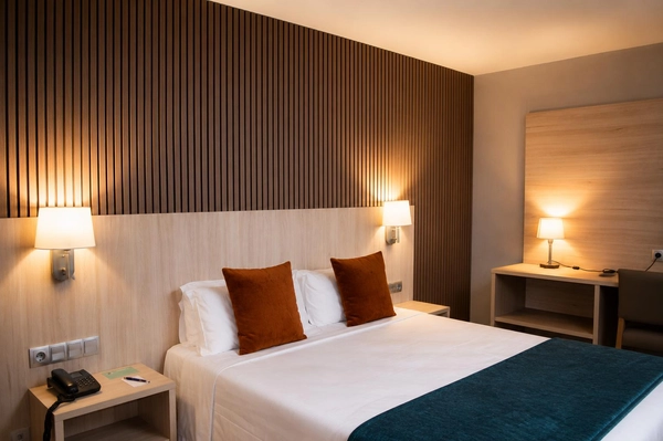 Dormitorio de hotel moderno con cama, mesita, lámparas y Hotel Best Andorra Center, Andorra la Vella  | Best Hotels.