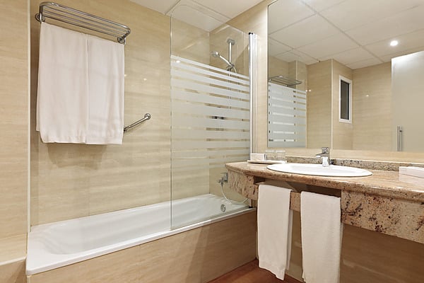 Badezimmer mit Dusche und Badewanne; Waschbecken mit Spiegel. Best Oasis Park, Salou | Offizielle Website | Bester Preis
