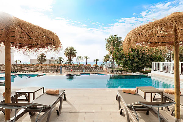 Hotel Best Siroco, Benalmádena | Best Hotels | Mejor Precio: piscina y tumbonas bajo sombrillas de paja, vistas al mar y palmeras.