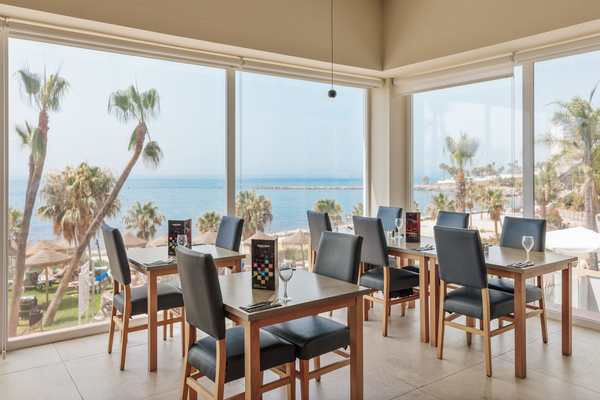 Comedor elegante de hotel con vistas al mar y palmeras, ideal para Hotel Best Benalmádena, Costa del Sol | Web oficial.