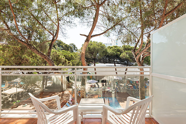 Terraza con sillas blancas y vista a piscina, árboles y hotel. Best Oasis Park, Salou  | Best hotels | Mejor precio
