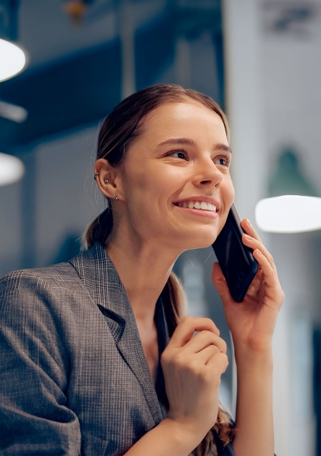a woman is smiling while talking on a cell phone
