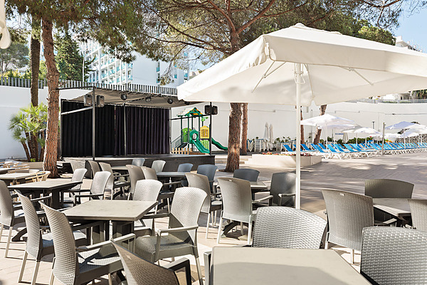 Terraza de hotel con mesas, sillas, escenario y tumbonas junto a la piscina. Best Oasis Park, Salou  | Best hotels | Mejor precio