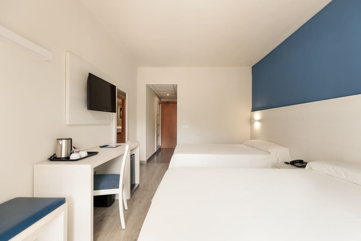 Modernes Hotelzimmer mit zwei Betten, Schreibtisch und TV. Best Oasis Park