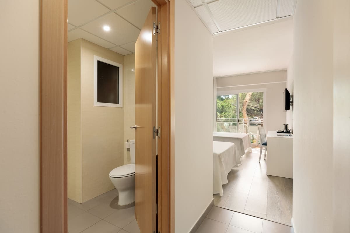 Modern Hotelzimmer mit Bad und Balkon: Doppelbetten, Schreibtisch, TV und Fenster mit Blick ins Grüne Best Oasis Park