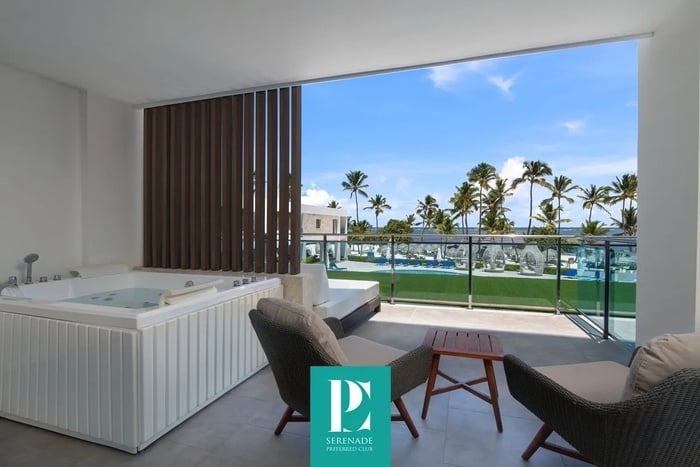 a balcony with a jacuzzi and chairs and a sign that says serenade