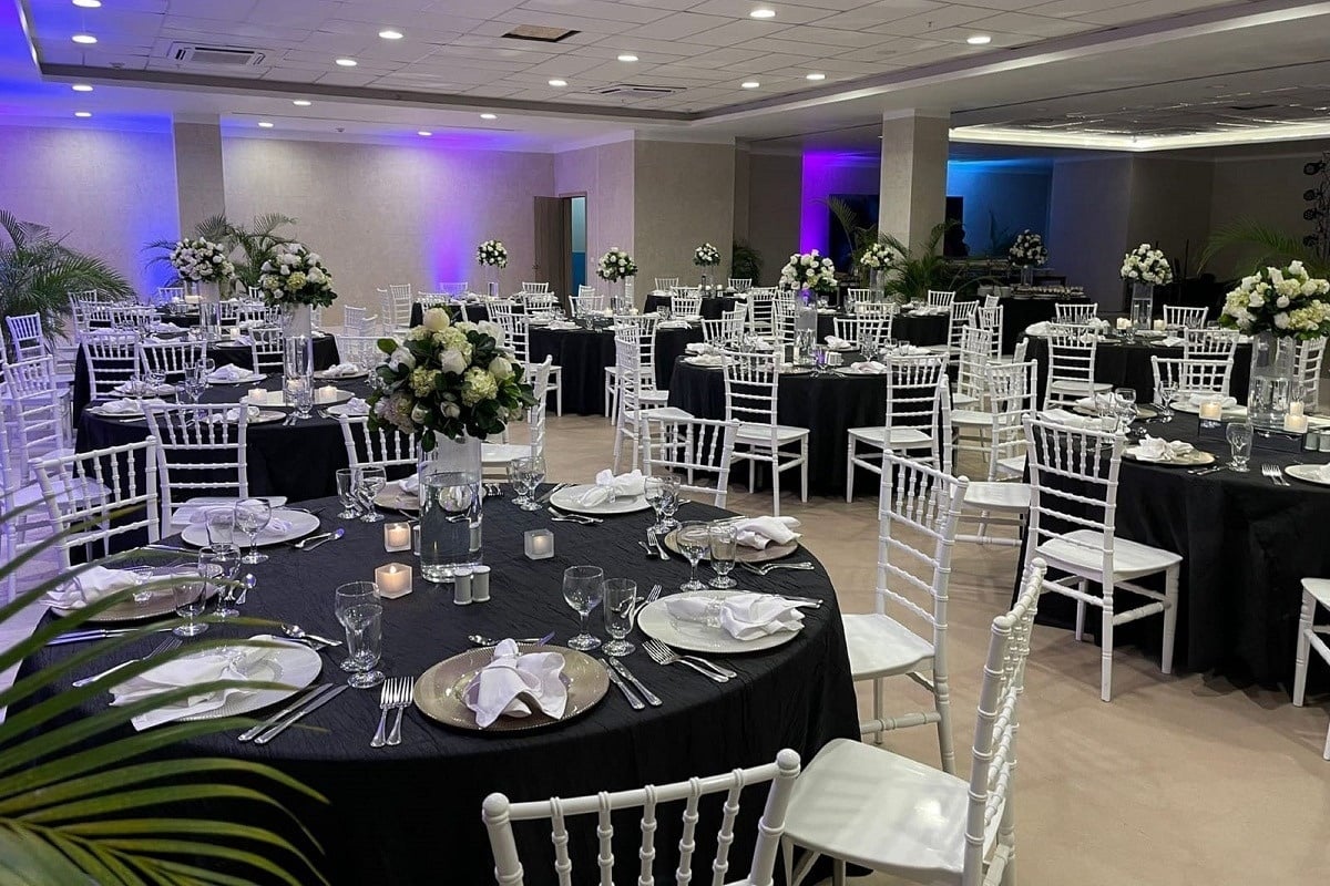 una habitación llena de mesas y sillas para una boda