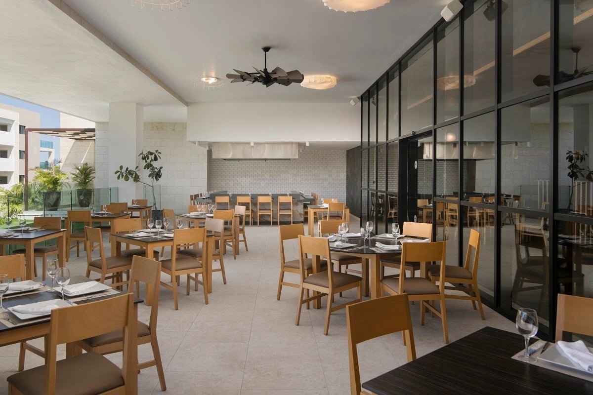 a restaurant with tables and chairs and a ceiling fan