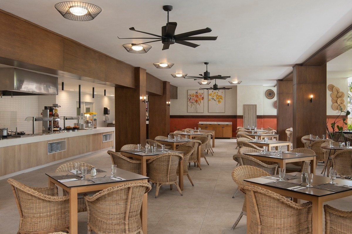 a restaurant with tables and chairs and a ceiling fan