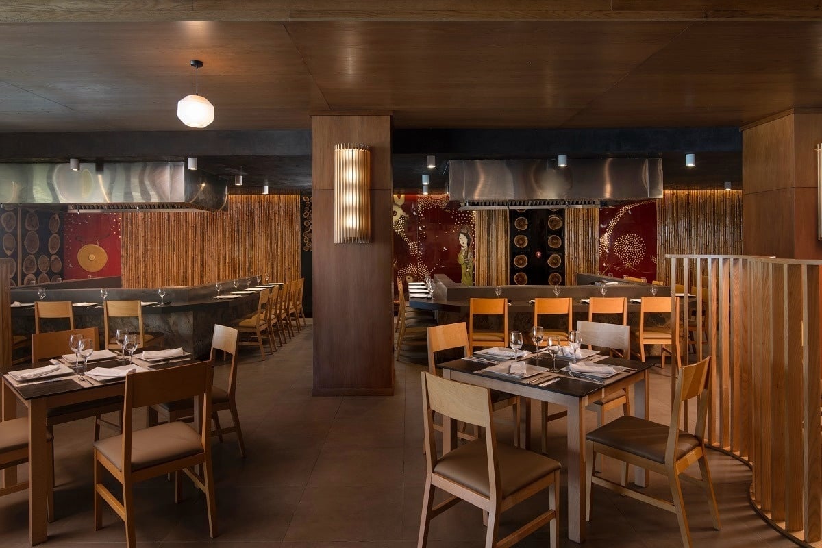 a restaurant with wooden tables and chairs and stainless steel appliances