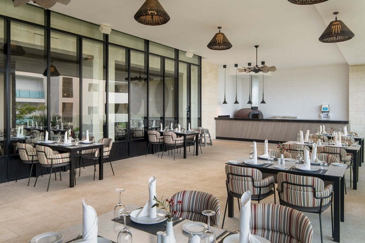 a restaurant with tables and chairs and a pizza oven