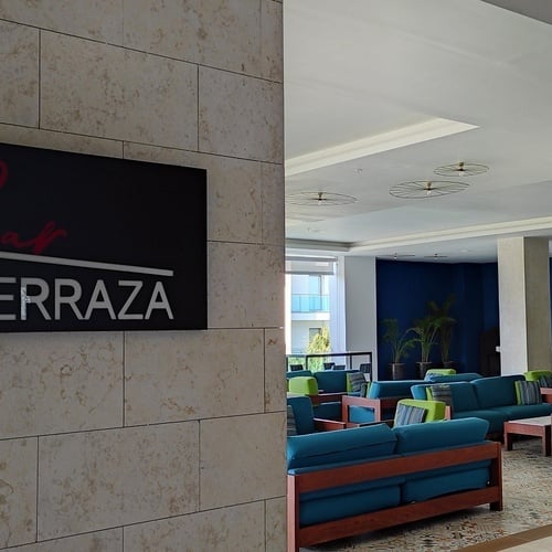 гостиная с синими диванами и столами и табличкой terraza