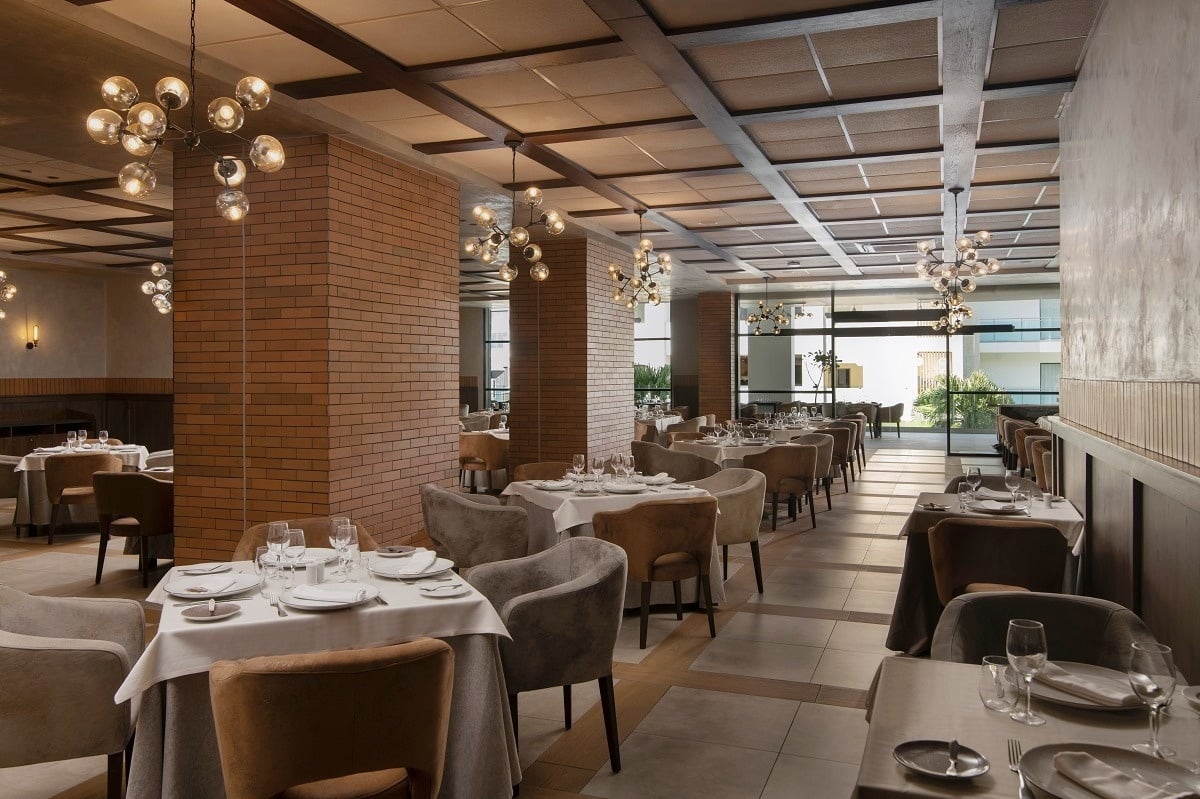 a restaurant with tables and chairs and a brick wall