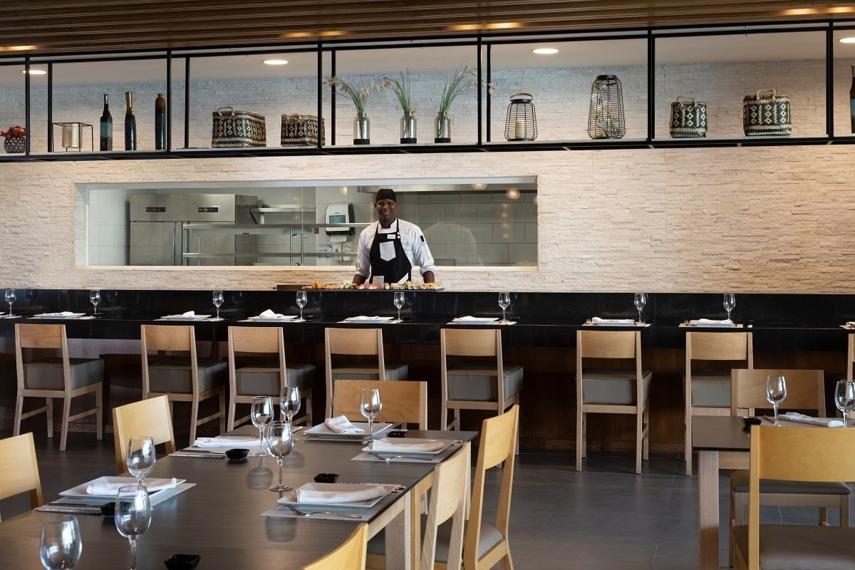 a chef stands behind a counter in a restaurant