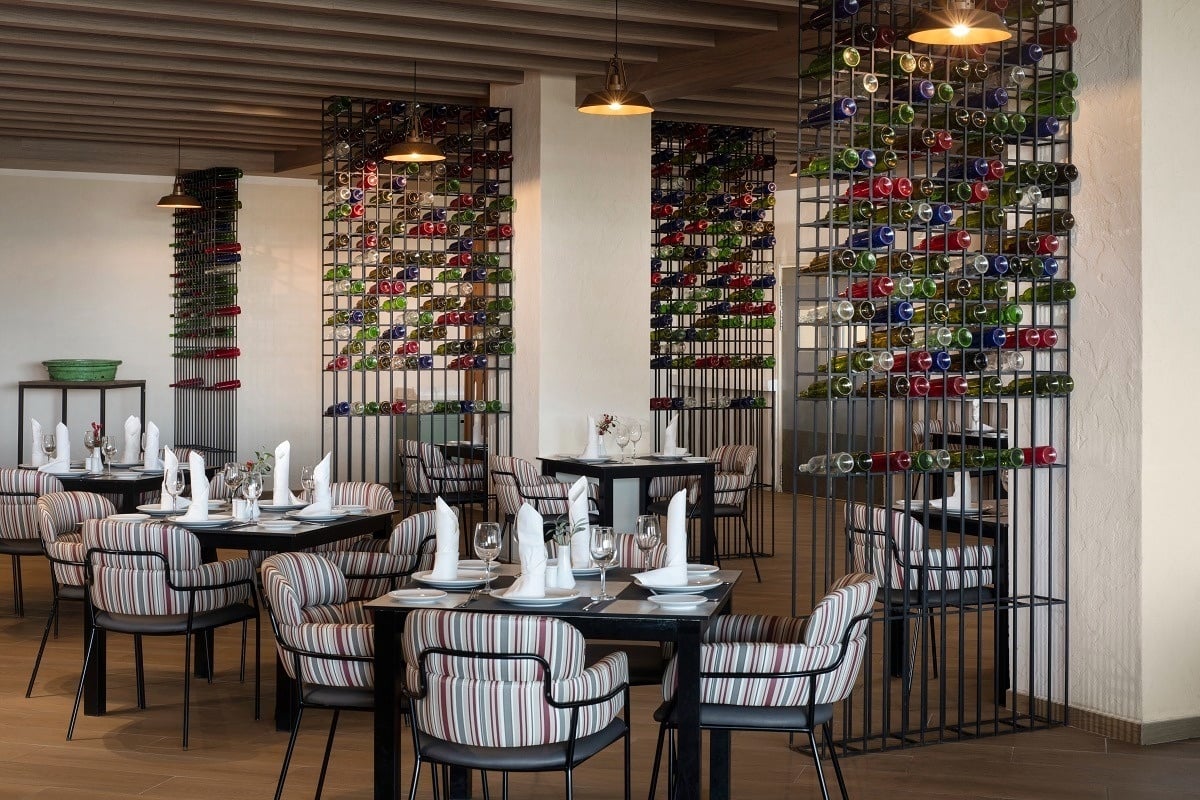 a restaurant with tables and chairs and bottles on the wall