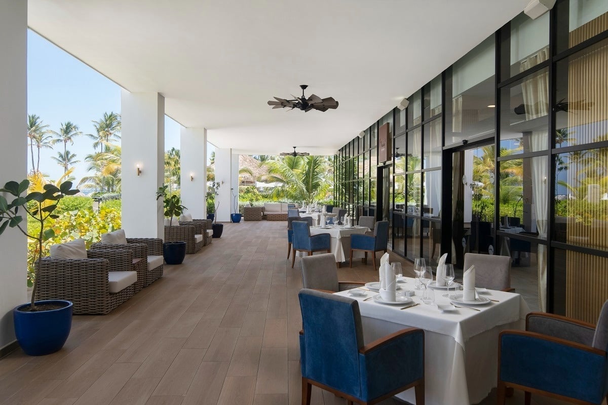 a restaurant with tables and chairs and a ceiling fan