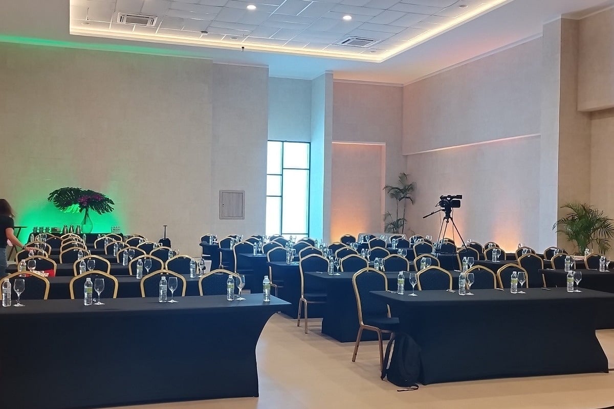 una sala de conferencias llena de mesas y sillas negras