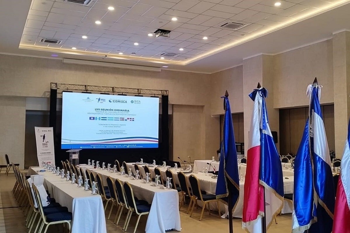 una sala de conferencias con mesas y sillas y banderas