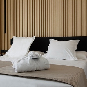 una habitación de hotel con una cama blanca y una pared de madera