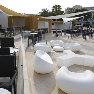 eine Terrasse mit vielen weißen Stühlen und Tischen