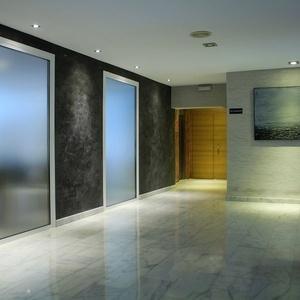 un pasillo con puertas de vidrio y una pintura en la pared