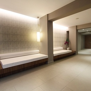 ein Flur mit zwei weißen Bänken und einem Blumentopf