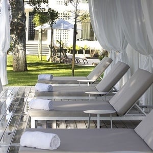 una fila de tumbonas con toallas enrolladas sobre ellas