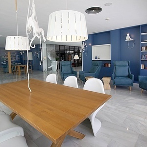 a room with blue walls and white chairs and a wooden table