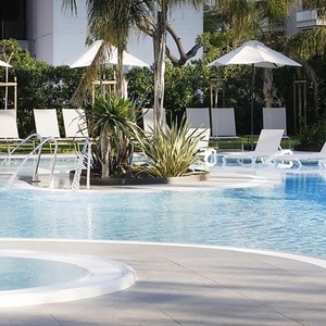 una piscina rodeada de sillas y sombrillas y un jacuzzi