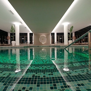 a large indoor swimming pool with green tiles