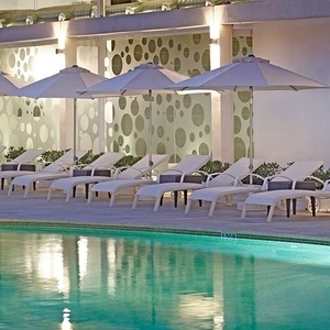 una fila de sillas y sombrillas alrededor de una piscina