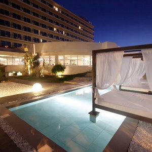 ein weißer Himmelbett neben einem Swimmingpool