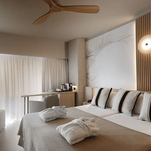 una habitación de hotel con una cama y batas de baño