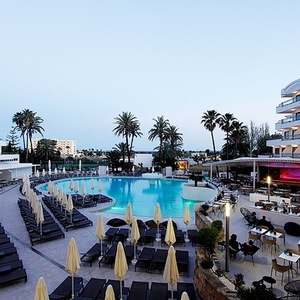 a large swimming pool surrounded by chairs and umbrellas
