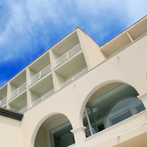 un edificio blanco con balcones y arcos y un cielo azul en el fondo