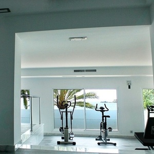 una habitación blanca con una piscina y un gimnasio