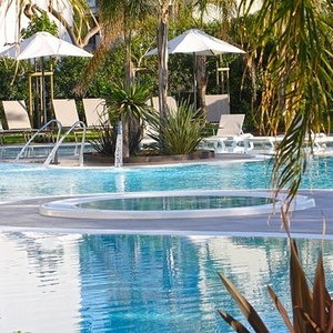 una gran piscina rodeada de sillas y sombrillas