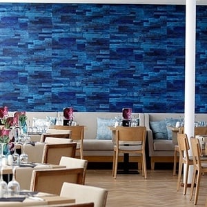 a restaurant with tables and chairs and a blue wall