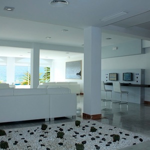 una sala de estar con sofás blancos y sillas