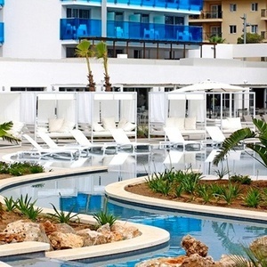 una piscina rodeada de sillas y sombrillas en un resort