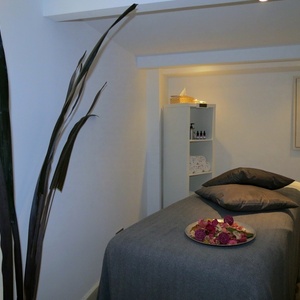 una cama en un spa con un plato de flores encima