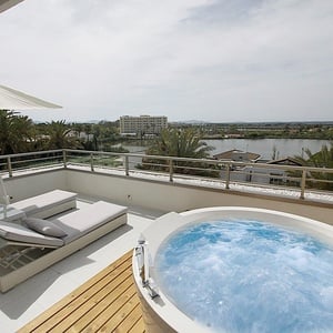 a hot tub on a balcony overlooking a lake