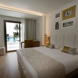 a hotel room with a large bed and pictures on the wall