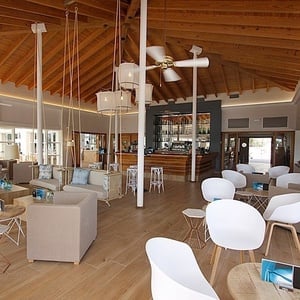 a restaurant with a wooden ceiling and white chairs