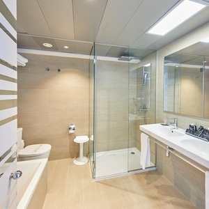 un baño con dos lavabos y una ducha de vidrio