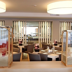 ein Speisesaal mit einem Tisch und Stühlen und drei Laternen